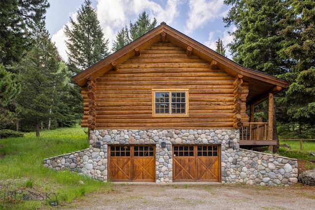 49824 Gallatin Rd, Big Sky, MT 59730 - view of home's exterior featuring log siding, a garage, stone siding, and driveway