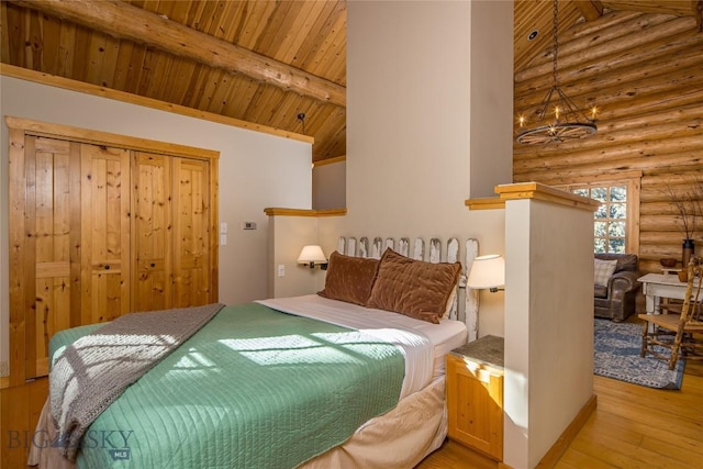 49824 Gallatin Rd, Big Sky, MT 59730 - bedroom featuring rustic walls, light wood-type flooring, a wooden ceiling with exposed beams, high vaulted ceiling, and a chandelier