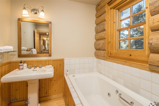 49824 Gallatin Rd, Big Sky, MT 59730 - full bathroom with rustic walls, a whirlpool tub, a wainscoted wall, and wood finished floors