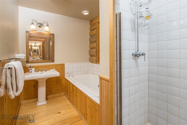 49824 Gallatin Rd, Big Sky, MT 59730 - bathroom featuring a bath, a stall shower, and wood finished floors