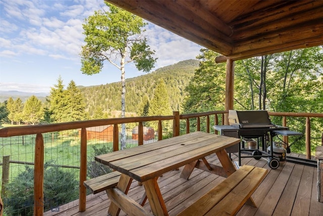 49824 Gallatin Rd, Big Sky, MT 59730 - wooden deck featuring a wooded view, outdoor dining area, and a mountain view