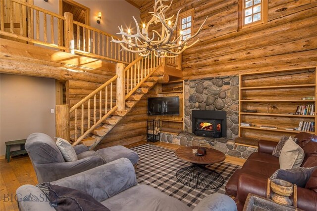 49824 Gallatin Rd, Big Sky, MT 59730 - living room with a towering ceiling, hardwood / wood-style flooring, stairway, a chandelier, and rustic walls