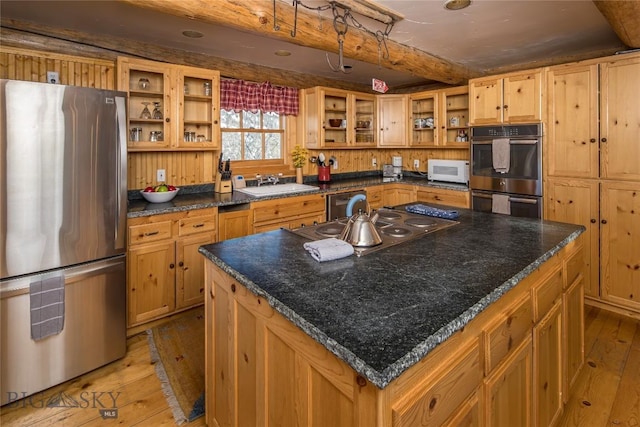 49824 Gallatin Rd, Big Sky, MT 59730 - kitchen with appliances with stainless steel finishes, open shelves, light wood-style flooring, a kitchen island, and glass insert cabinets