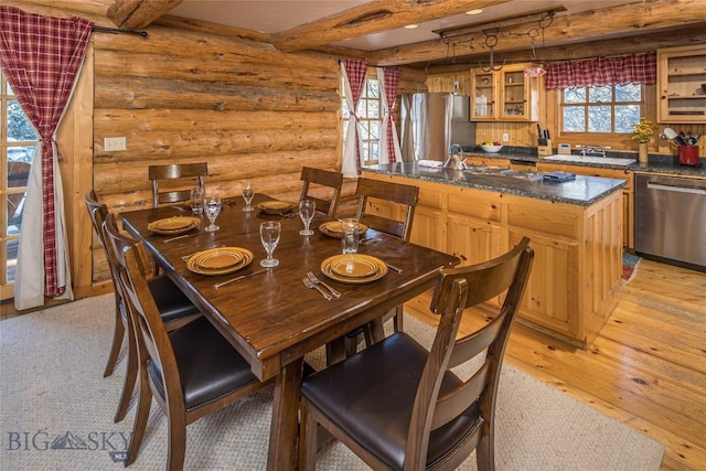 49824 Gallatin Rd, Big Sky, MT 59730 - dining space with rustic walls, light wood-type flooring, and beamed ceiling