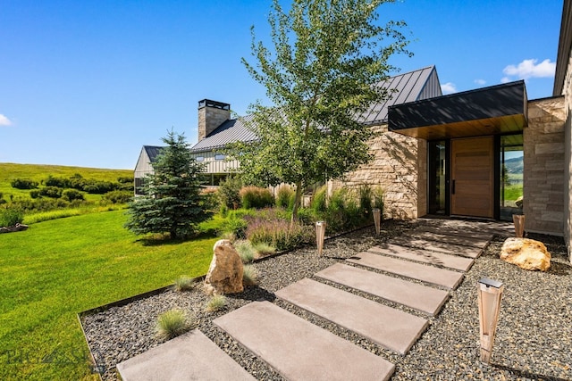 1878 Star Ridge Rd, Bozeman, MT 59715 - view of front of property featuring a standing seam roof, a metal roof, a front lawn, stone siding, and a chimney