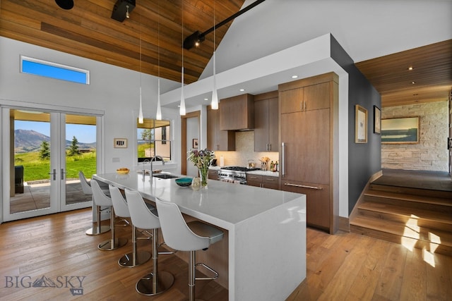 1878 Star Ridge Rd, Bozeman, MT 59715 - kitchen featuring wooden ceiling, high vaulted ceiling, a kitchen breakfast bar, modern cabinets, and light wood-style flooring
