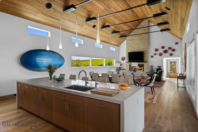 1878 Star Ridge Rd, Bozeman, MT 59715 - kitchen featuring a wood ceiling with exposed beams, high vaulted ceiling, dark wood-style flooring, a stone fireplace, and open floor plan