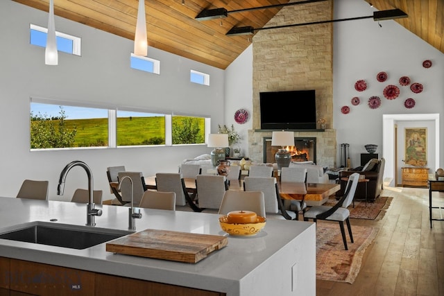 1878 Star Ridge Rd, Bozeman, MT 59715 - kitchen featuring wood ceiling, high vaulted ceiling, hardwood / wood-style floors, a stone fireplace, and open floor plan