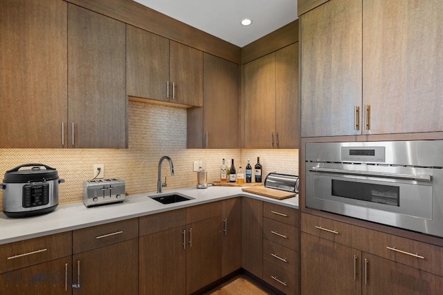 1878 Star Ridge Rd, Bozeman, MT 59715 - kitchen featuring oven, decorative backsplash, light countertops, and dark brown cabinetry