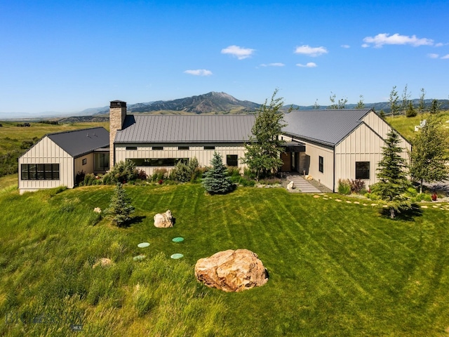 1878 Star Ridge Rd, Bozeman, MT 59715 - rear view of house with board and batten siding, a metal roof, a chimney, a yard, and a mountain view