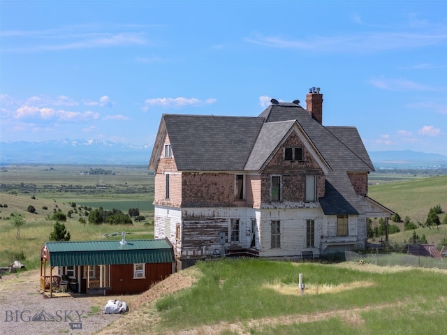 5835 Spaulding Bridge Rd, Belgrade, MT 59714 - view of front of property with a chimney, a shingled roof, a view of countryside, and an outdoor structure