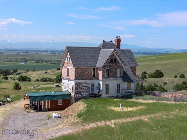 5835 Spaulding Bridge Rd, Belgrade, MT 59714 - view of front of home with a chimney, a view of countryside, a shingled roof, and stone siding