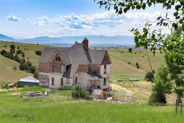 5835 Spaulding Bridge Rd, Belgrade, MT 59714 - back of house with stone siding, a chimney, a mountain view, and a view of countryside