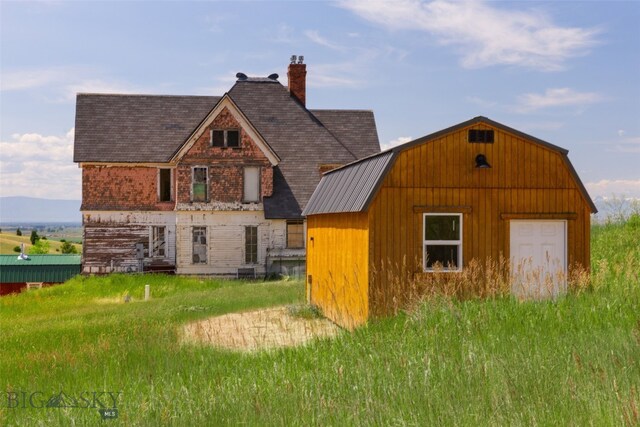 5835 Spaulding Bridge Rd, Belgrade, MT 59714 - back of house with a chimney, a shingled roof, and a gambrel roof