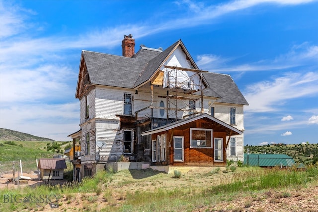 5835 Spaulding Bridge Rd, Belgrade, MT 59714 - rear view of house with a balcony, a chimney, and roof with shingles