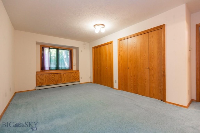 2200 W Dickerson Unit 46, Bozeman, MT 59718 - unfurnished bedroom featuring a baseboard heating unit, two closets, carpet floors, and a textured ceiling