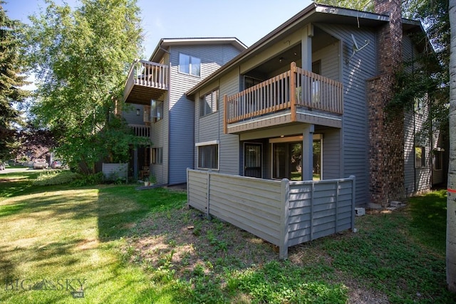 2200 W Dickerson Unit 46, Bozeman, MT 59718 - rear view of house featuring a balcony, a chimney, and a yard