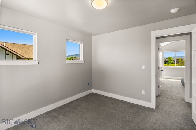 3139 Blackbird Dr, Bozeman, MT 59718 - empty room featuring dark colored carpet, plenty of natural light, and a smoke detector