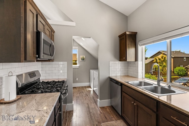 3139 Blackbird Dr, Bozeman, MT 59718 - kitchen with stainless steel appliances, independent washer and dryer, dark wood-type flooring, dark brown cabinetry, and decorative backsplash