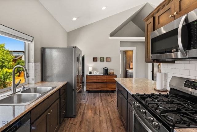 3139 Blackbird Dr, Bozeman, MT 59718 - kitchen featuring stainless steel appliances, lofted ceiling, tasteful backsplash, dark wood-style floors, and light stone counters