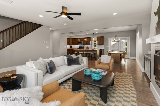 3139 Blackbird Dr, Bozeman, MT 59718 - living room featuring wood finished floors, a fireplace, a ceiling fan, a chandelier, and stairway