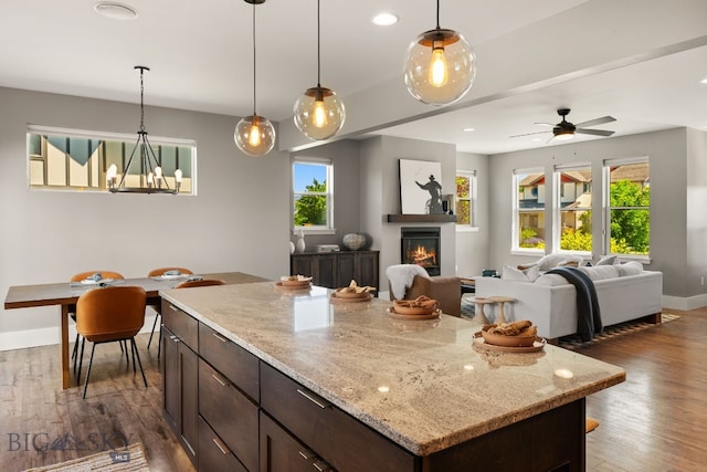 3139 Blackbird Dr, Bozeman, MT 59718 - kitchen featuring healthy amount of natural light, wood finished floors, dark brown cabinets, decorative light fixtures, and recessed lighting