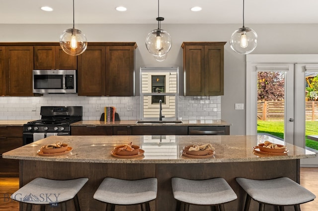 3139 Blackbird Dr, Bozeman, MT 59718 - kitchen featuring stainless steel appliances, a breakfast bar, tasteful backsplash, and recessed lighting