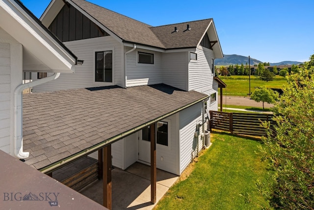 3139 Blackbird Dr, Bozeman, MT 59718 - view of side of property with a mountain view, board and batten siding, a patio area, and roof with shingles