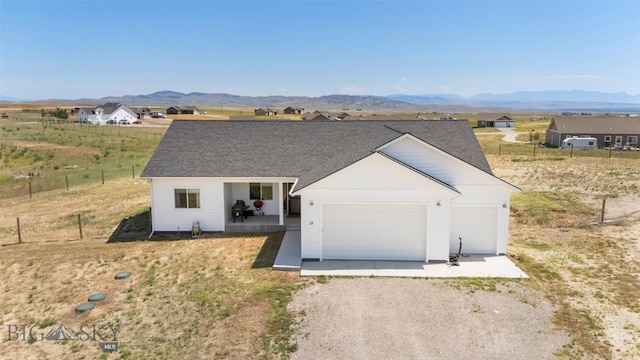 15 Santa Fe Trl, Three Forks, MT 59752 - single story home with a mountain view, driveway, a garage, and a shingled roof