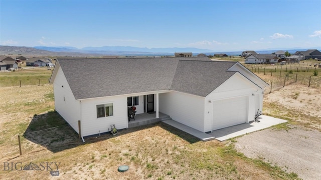15 Santa Fe Trl, Three Forks, MT 59752 - single story home featuring an attached garage, roof with shingles, driveway, a residential view, and a mountain view