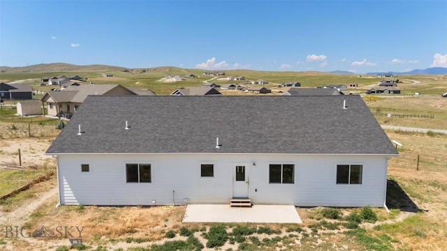15 Santa Fe Trl, Three Forks, MT 59752 - back of house with a patio area, a shingled roof, and a mountain view