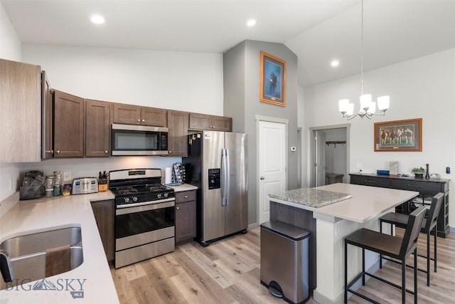 15 Santa Fe Trl, Three Forks, MT 59752 - kitchen featuring appliances with stainless steel finishes, high vaulted ceiling, a chandelier, light countertops, and a kitchen breakfast bar