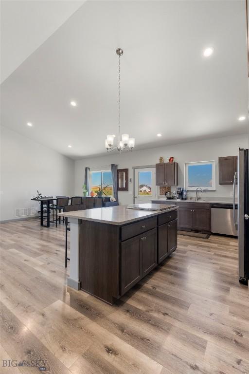 15 Santa Fe Trl, Three Forks, MT 59752 - kitchen with appliances with stainless steel finishes, dark brown cabinetry, light wood finished floors, recessed lighting, and a center island
