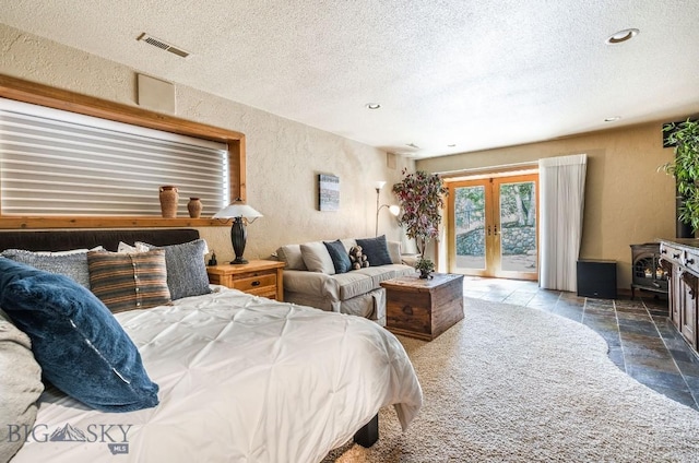 953 Angel Point Rd, Lakeside, MT 59922 - bedroom with a textured wall, stone tile flooring, access to outside, a textured ceiling, and french doors