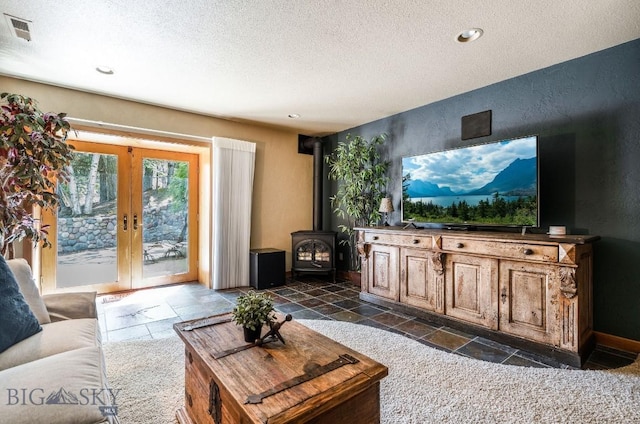 953 Angel Point Rd, Lakeside, MT 59922 - living area with a textured ceiling, stone tile flooring, a wood stove, french doors, and recessed lighting