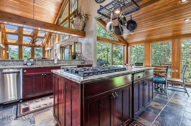 953 Angel Point Rd, Lakeside, MT 59922 - kitchen featuring stainless steel appliances, stone tile floors, wooden ceiling, reddish brown cabinets, and a kitchen island