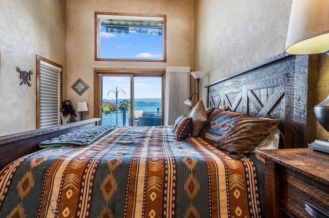 953 Angel Point Rd, Lakeside, MT 59922 - bedroom featuring access to outside, a high ceiling, and a textured wall