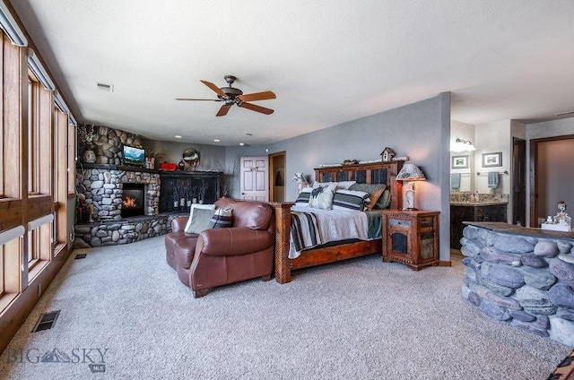 953 Angel Point Rd, Lakeside, MT 59922 - bedroom featuring a stone fireplace, carpet flooring, ceiling fan, and ensuite bathroom