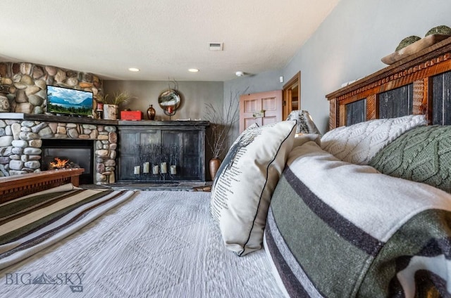 953 Angel Point Rd, Lakeside, MT 59922 - bedroom with a stone fireplace, recessed lighting, and a textured ceiling