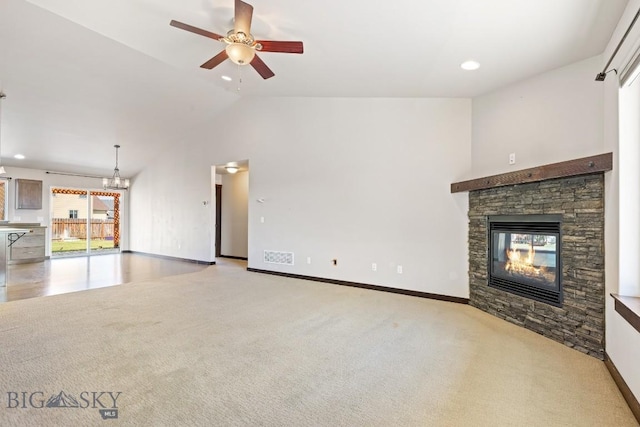 343 Stewart Loop, Bozeman, MT 59718 - unfurnished living room with a stone fireplace, a ceiling fan, light carpet, lofted ceiling, and a chandelier