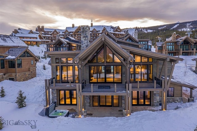 snow covered house with stone siding