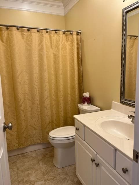 bathroom featuring tile floors, ornamental molding, vanity, and toilet