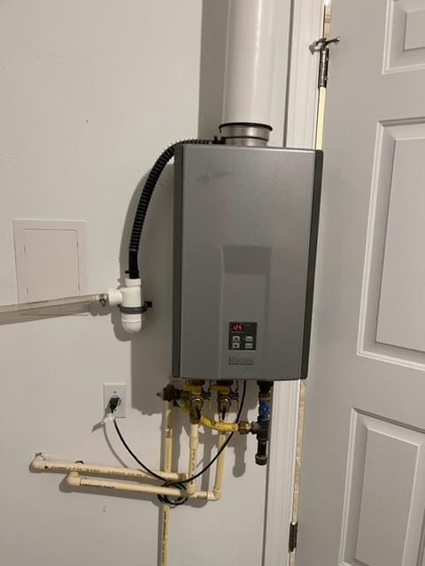 utility room featuring tankless water heater