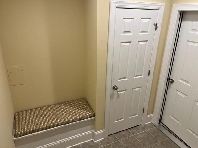 mudroom with dark tile flooring