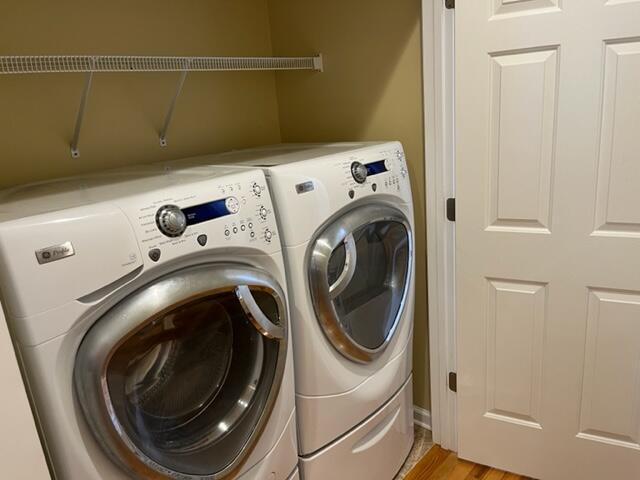 laundry area with light wood-type flooring and separate washer and dryer