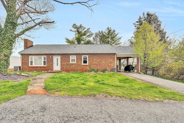 single story home featuring a front yard, a carport, and central air condition unit