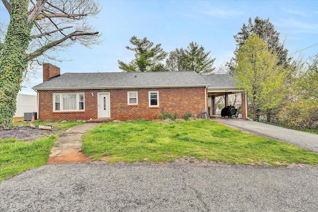 ranch-style house featuring a front yard, central air condition unit, and a carport