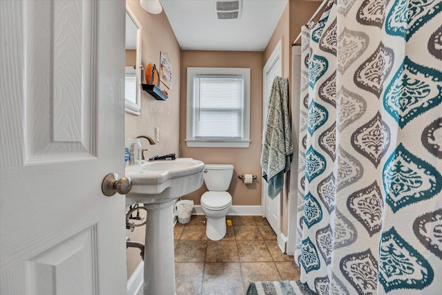 bathroom with tile flooring and toilet