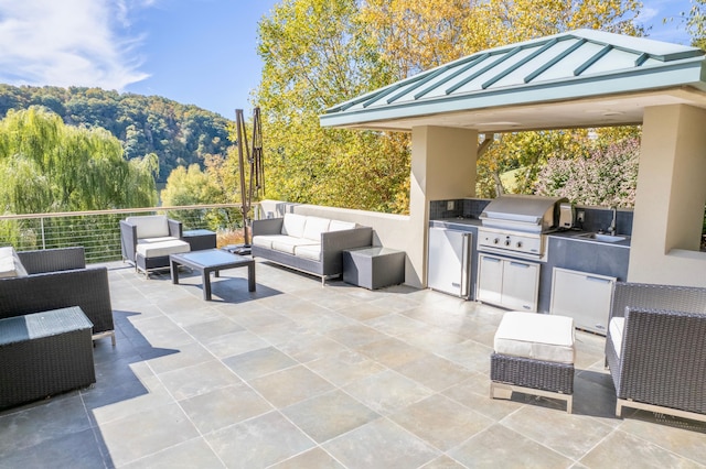 view of patio / terrace with a mountain view, area for grilling, an outdoor living space, and sink