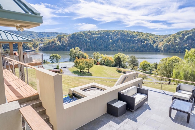 exterior space with a water view and an outdoor living space with a fire pit